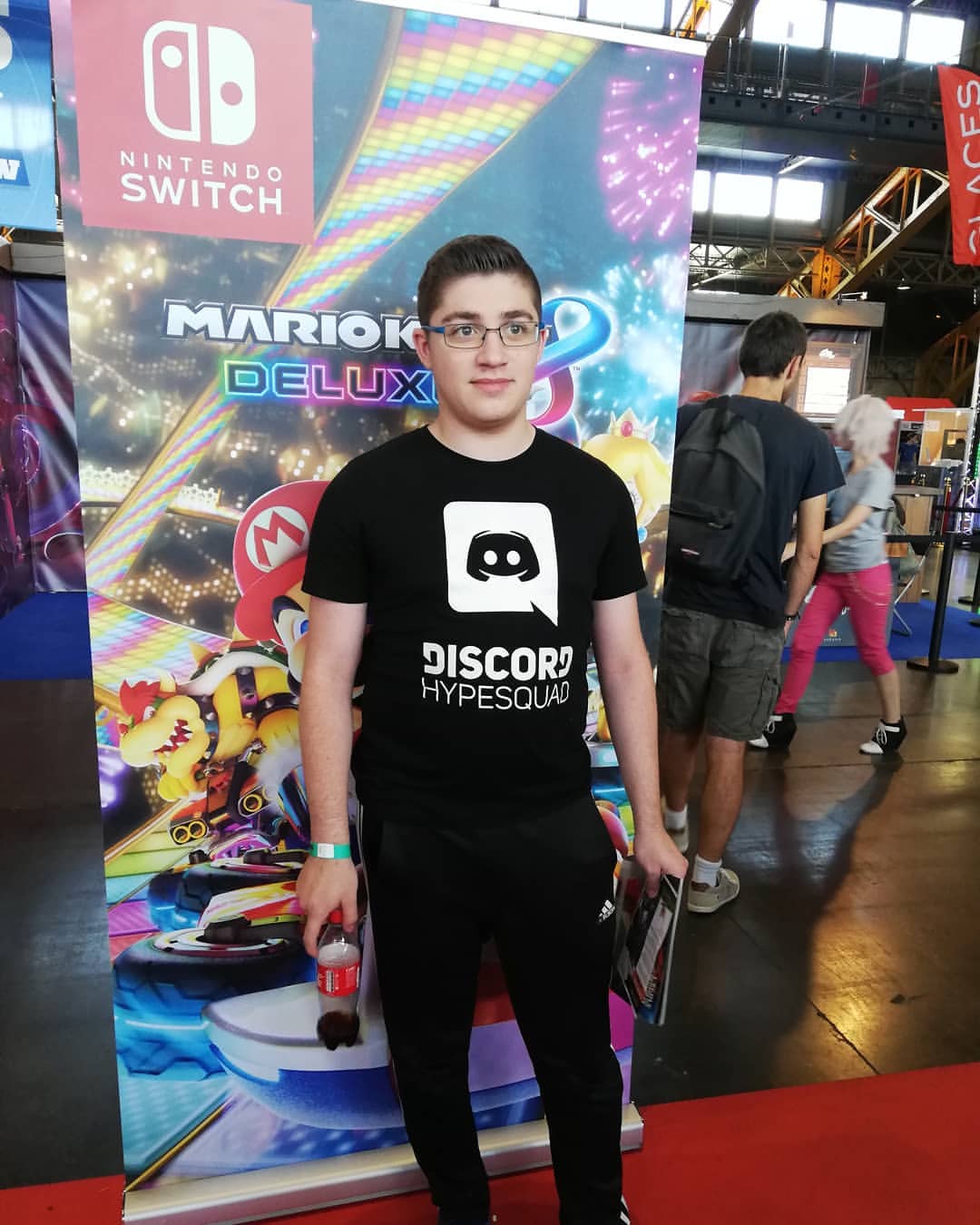 Kevin Martinez, fondateur de GTwo Games, en t-shirt Discord HypeSquad devant un stand Nintendo Switch au TGS de Lyon